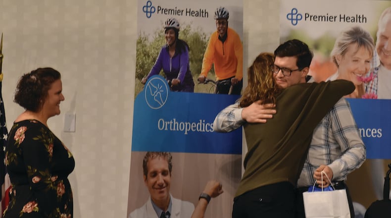 Travis Osborne, a survivor of the Aug. 4, 2019 mass shooting in the Oregon District, hugs Jessamine Sothard, a nurse practitioner (middle), and then Jamie Brunicardi, a nurse practitioner (left), who were two of Osborne's caregivers while Osborne was hospitalized following the mass shooting. SAMANTHA WILDOW\STAFF