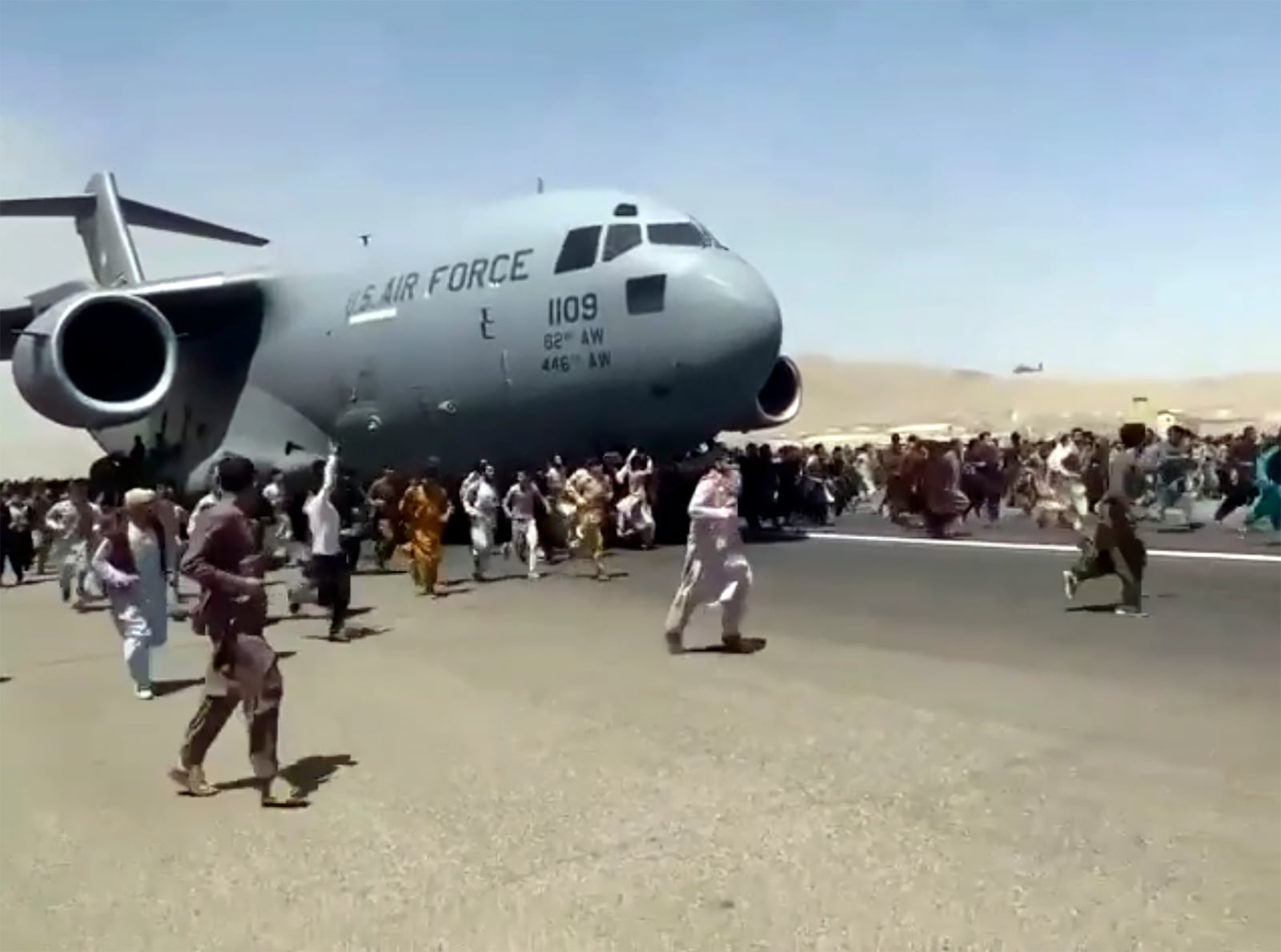 FILE - Hundreds of people desperate to escape Afghanistan run alongside a U.S. Air Force plane as it moves down a runway of the international airport in Kabul, Monday, Aug.16. 2021. (AP Photo, File)