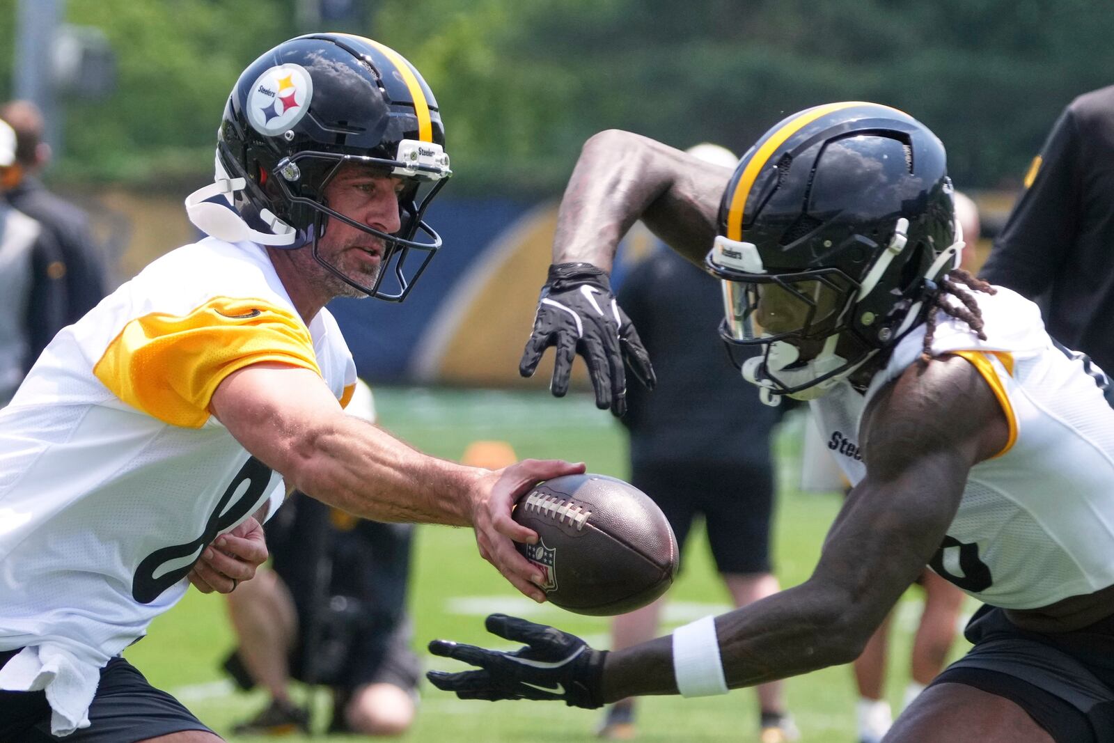 Pittsburgh Steelers quarterback Aaron Rodgers, left hands off to running back Kaleb Johnson during practice at NFL football minicamp, Tuesday, June 10, 2025, in Pittsburgh. (AP Photo/Gene J. Puskar)