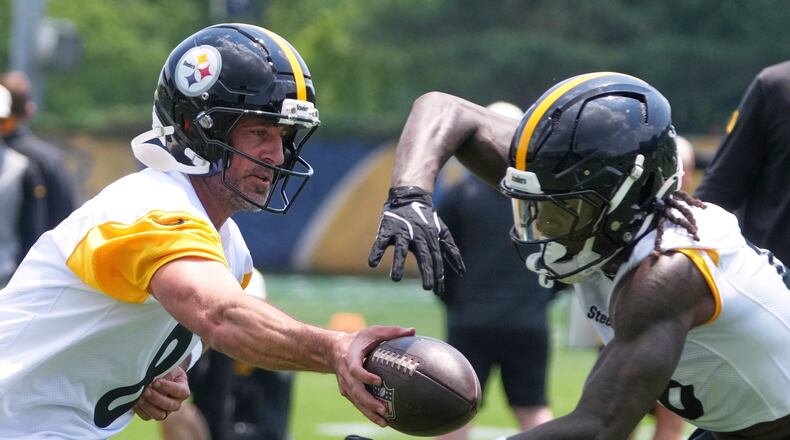 Pittsburgh Steelers quarterback Aaron Rodgers, left hands off to running back Kaleb Johnson during practice at NFL football minicamp, Tuesday, June 10, 2025, in Pittsburgh. (AP Photo/Gene J. Puskar)