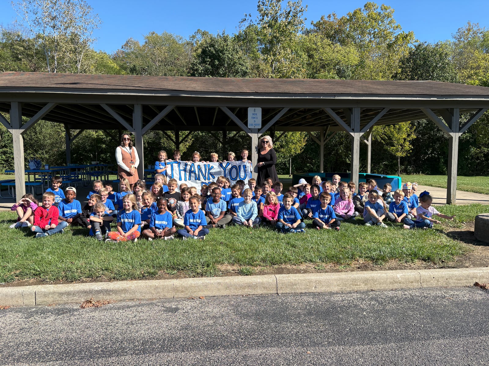 Four classes of Clearcreek Elementary School students in a mix of first graders and kindergartners sit in front of the new outdoor classroom Thursday, Oct. 9, 2025, in the shelter behind the school. JEN BALDUF/STAFF
