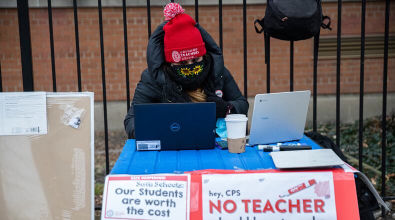 Teacher Melissa Vozar sits outside of Suder Elementary in Chicago to teach a virtual class Monday, Jan. 11, 2021. Chicago Public Schools students began their return to the classroom Monday as school doors opened to thousands of pre-kindergarten and some special education students. (Anthony Vazquez/Chicago Sun-Times via AP)