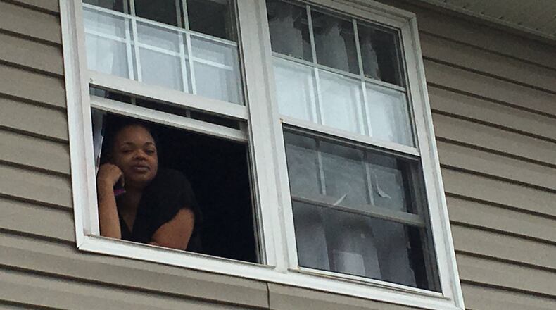 Destynee Gregory talks to a reporter from her second floor window at Meadowlark Apartments in Trotwood. She has two preschool age children, including one with a weakened immune system.