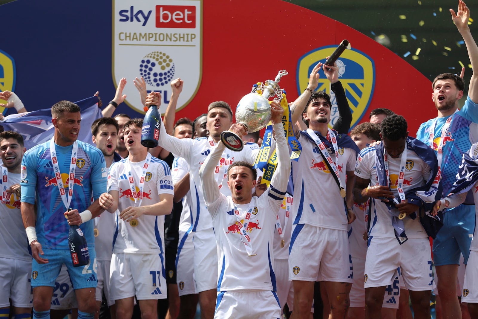 Leeds United's Ethan Ampadu and teammates celebrate with the trophy after being crowned champions following the English Football League Championship soccer match against Plymouth Argyle, at Home Park, in Plymouth, England, Saturday May 3, 2025. (Steven Paston/PA via AP)