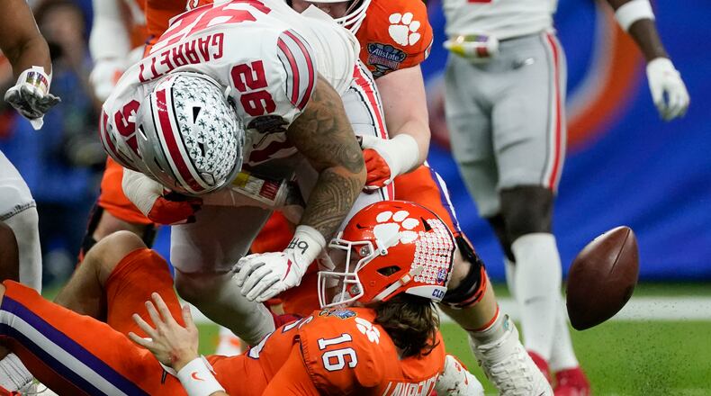 Ohio State defensive tackle Haskell Garrett force a fumble by Clemson quarterback Trevor Lawrence during the second half of the Sugar Bowl NCAA college football game Friday, Jan. 1, 2021, in New Orleans. (AP Photo/John Bazemore)