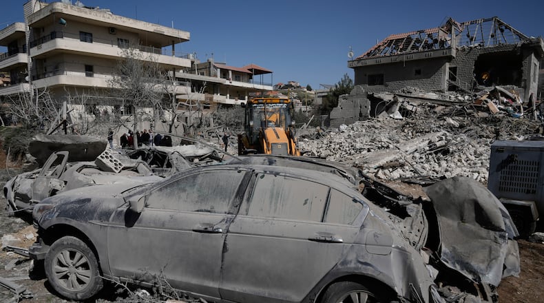 People gather near a building destroyed in an Israeli strike in the village of Bednayel in eastern Lebanon, Saturday, Feb. 21, 2026. (AP Photo/Bilal Hussein)