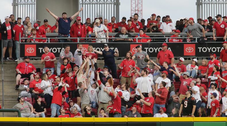Fans try to catch a home run hit by Andres Gimenez, of the Guadians, against the Reds in the ninth inning on Opening Day on Tuesday, April 12, 2022, at Great American Ball Park in Cincinnati. David Jablonski/Staff