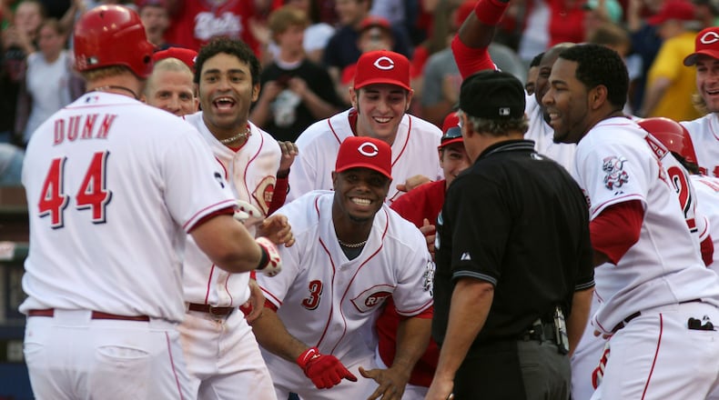 Cincinnati Reds' Adam Dunn is welcomed by Ken Griffey Jr. (3) and other teammates after hitting a three-run home run off Cleveland Indians pitcher Masa Kobayashi in the ninth inning of a baseball game in Cincinnati on Saturday, May 17, 2008. The Reds won 4-2. (AP Photo/Tom Uhlman)