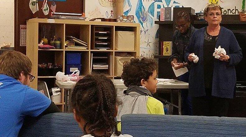 Beverley Knight-Stukenborg passes out candy hearts to kids at the Prairies Youth Center during a recent program addressing teen dating violence. (Air Force photos/Laura McGowan)
