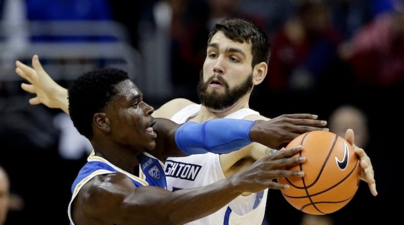 FILE- In this Nov. 20, 2017 file photo, Creighton's Manny Suarez, right, tries to block a pass by UCLA's Aaron Holiday, during an NCAA college basketball game in Kansas City, Mo. With one year of eligibility left, the 6-foot-10, 250-pounder Suarez transferred from Division II Adelphi to Division I Creighton, and he's playing a significant role off the bench. He's among fewer than 10 transfers who made the move from D2 to D1 this season. (AP Photo/Charlie Riedel, File)