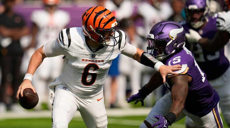 Cincinnati Bengals quarterback Jake Browning (6) is chased by Minnesota Vikings linebacker Dallas Turner (15) during the second half of an NFL football game, Sunday, Sept. 21, 2025, in Minneapolis. (AP Photo/Mike Stewart)
