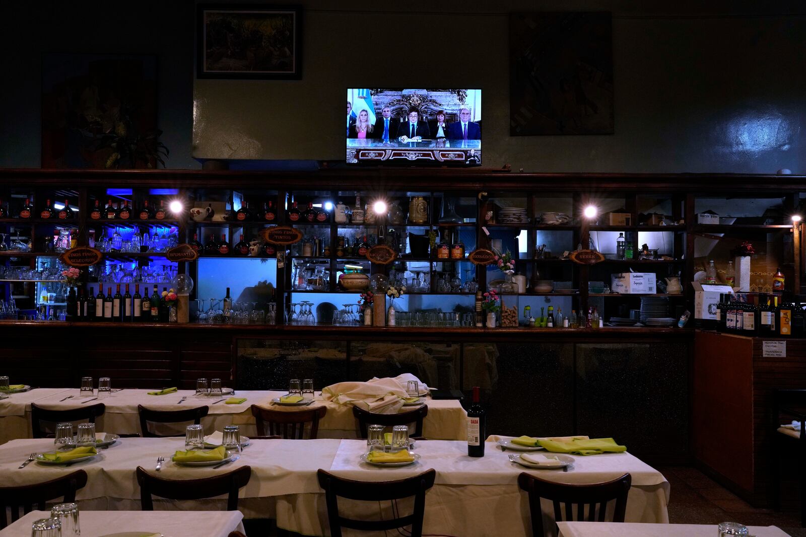 A television airs a national message by President Javier Milei, accompanied by members of his Cabinet, at a restaurant in Buenos Aires, Argentina, Friday, April 11, 2025. (AP Photo/Natacha Pisarenko)