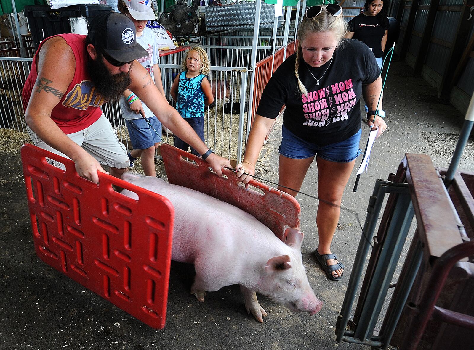 Chris and Tarryn Rothwell guide there pig to the scales to be weighed Thursday,  July 13, 2023 for the Montgomery County Fair. MARSHALL GORBY\STAFF