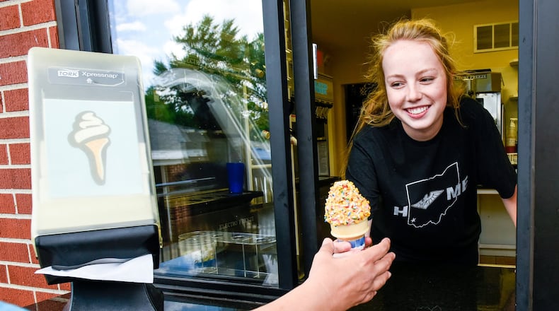 Kate Harvey, 16, serves an ice cream cone during her shift at Twist Ice Cream Company Wednesday, May 31 on Bethany Road in Liberty Twp. NICK GRAHAM/STAFF