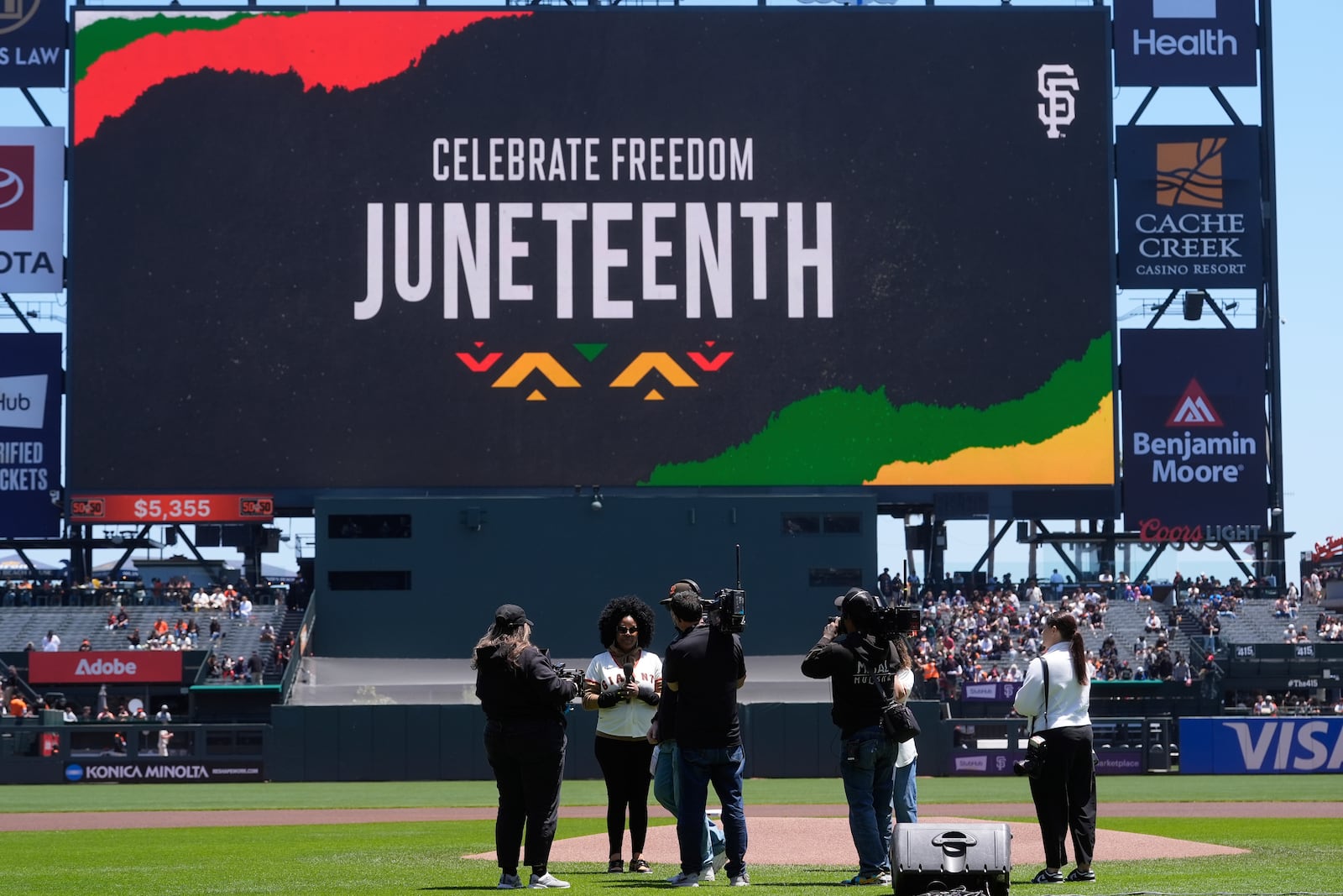 Lena Byrd-Miles, middle, prepares to sing Lift Every Voice, as part of the Juneteenth holiday, before a baseball game between the San Francisco Giants and the Cleveland Guardians in San Francisco, Thursday, June 19, 2025. (AP Photo/Jeff Chiu)