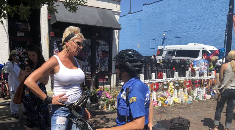 A Dayton police officer talks to a citizen outside of Ned Peppers and Hole in the Wall bars a few days after the Aug. 4 mass shooting. Police officials say there have been more traumatic events this year than any year in recent memory. CORNELIUS FROLIK / STAFF