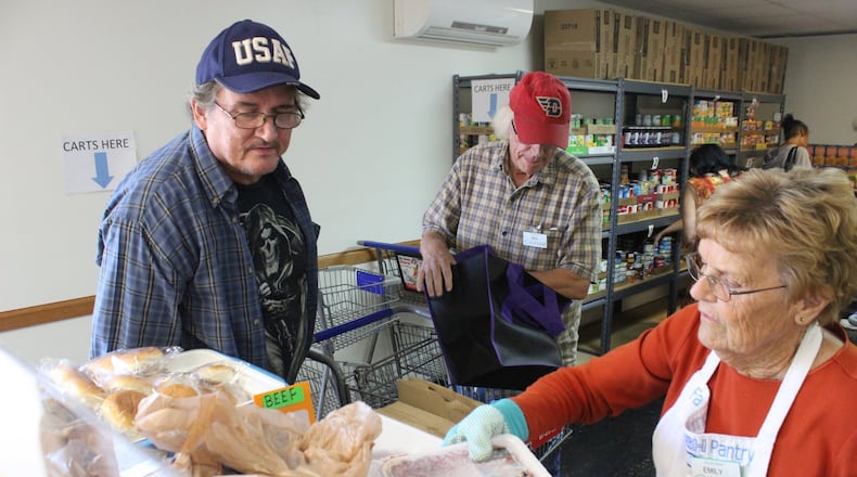 Veteran Dwight Martin Jr., left, selects from the frozen meat selection at the FISH Food Pantry in Fairborn from volunteer Emily Webb in this 2020 file photo.