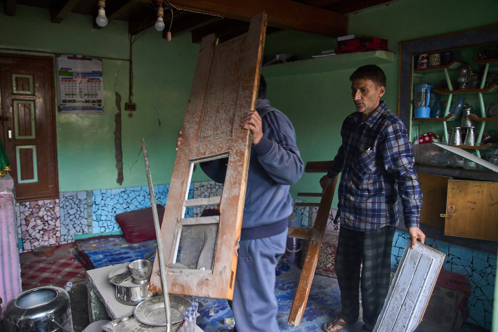 Kashmiri men salvage items in a neighbouring house after Indian forces blew up the family home of Ahsan Ul Haq Shiekh, a militant who officials say is involved in the deadly attack on tourists in Pahalgam, at Murran village in Pulwama, south of Srinagar, Indian controlled Kashmir, Saturday, April 26, 2025. (AP Photo/Dar Yasin)