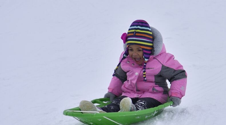 Alora Sheafe, 3, sleds down a hill at Voice of America MetroPark Thursday, February 18, 2021 in West Chester Township. Many schools in the area were off for a snow day. NICK GRAHAM / STAFF