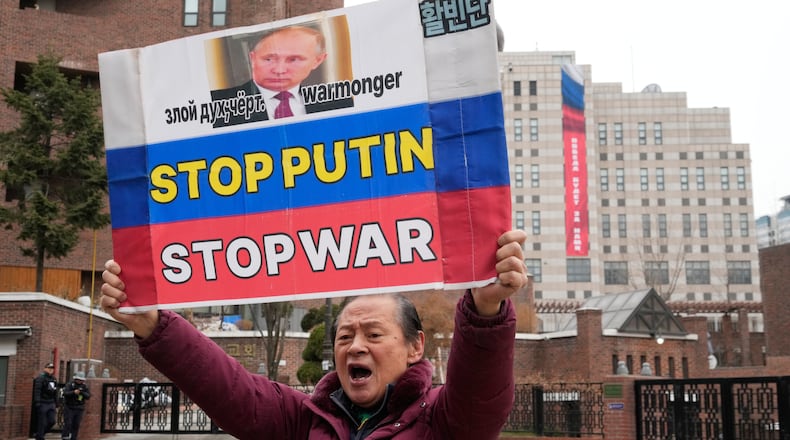 A South Korean protester holds a banner to denounce Russia's invasion of Ukraine on the fourth anniversary of the Russia-Ukraine war, near the Russian Embassy in Seoul, South Korea, Tuesday, Feb. 24, 2026. A banner reads "Victory will be ours." (AP Photo/Ahn Young-joon)