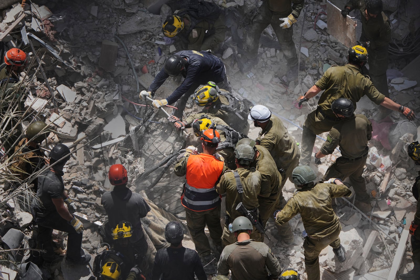 FILE - Israeli soldiers search for survivors amid the rubble of residential buildings destroyed by an Iranian missile strike in Bat Yam, central Israel, June 15, 2025. (AP Photo/Ariel Schalit, File)