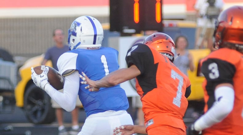 Meechi Harris (1 in blue) of Xenia scores a touchdown against Beavercreek.