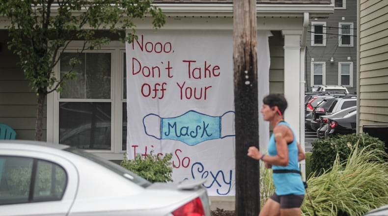 A jogger runs by UD housing that is sending a message to other students in this photo from Thursday, Sept. 3.