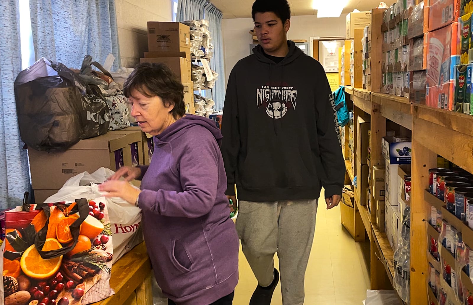 Two food pantry volunteers at Belmont Church sort through bags of supplies before the pantry opened to the community on Saturday, Nov. 8, 2025. STAFF/SYDNEY DAWES