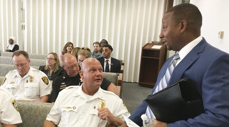 Brookville police Chief Douglass Jerome talks with Michael Colbert, assistant Montgomery County administrator for Development Services, during a commission meeting in August. CHRIS STEWART / STAFF