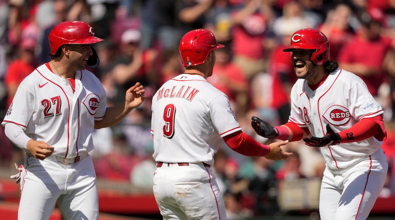 Cincinnati Reds' Eugenio Suárez (28), celebrates with Matt McLain (9) and Sal Stewart (27) after hitting a three-run homer during the sixth inning of a baseball game against the Boston Red Sox in Cincinnati, Sunday, March 29, 2026. (AP Photo/Carolyn Kaster)