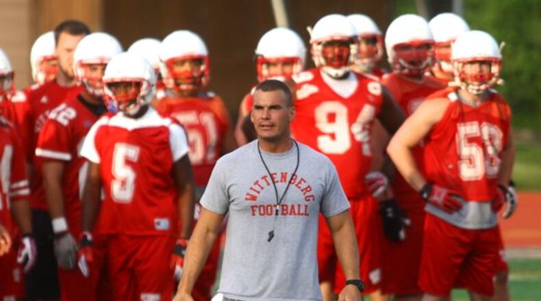 Defensive coordinator Sean Ross watches the defense as Wittenberg holds its first football practice of the 2013 season on Thursday, Aug. 15, 2013, in Springfield.