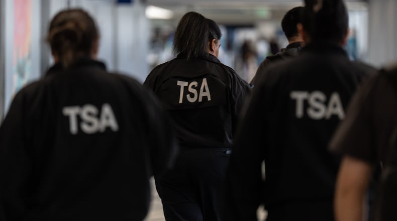 TSA agents walk through a terminal at Los Angeles International Airport in Los Angeles, Friday, March 27, 2026. (AP Photo/Jae C. Hong)