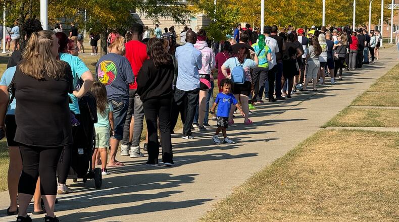 Parents wait in line at Springfield High School to pick up Simon Kenton Elementary students Monday. BILL LACKEY/STAFF