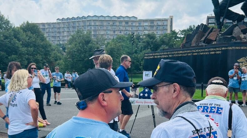 Stephen Lewis, 75, is a Vietnam veteran and Fairfield resident who on Aug. 10, 2024, took an Honor Flight trip out of the Dayton hub to Washington, D.C., with his son, Tim Lewis, of Fairfield. Pictured is the younger Lewis, left, talking to his dad in front of the World War II memorial. An easel in the background holds a photo of Stephen Lewis' dad, Earl E. Lewis, a WWII veteran and Fairfield resident who died in 2016. It was part of the Honor Flight's Honoring Yesterday's Heroes program. PROVIDED