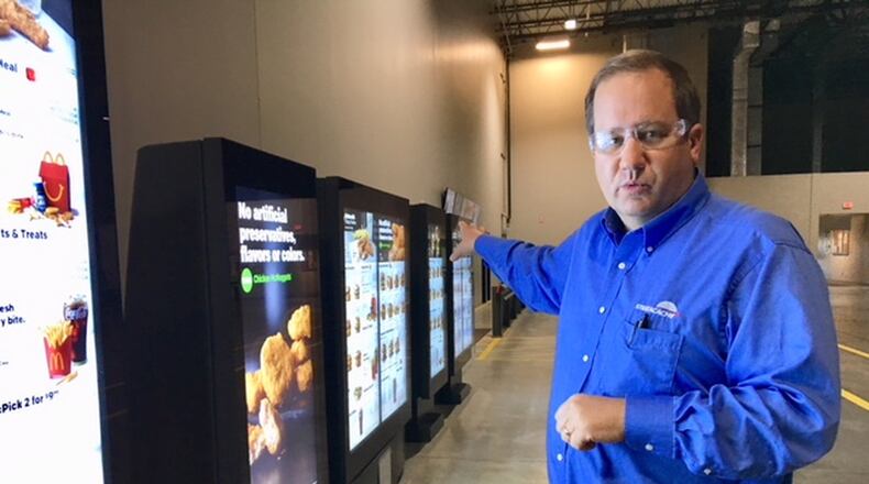 Chris Riegel, founder and chief executive of Stratacache, runs a company based in Dayton but increasingly busy in a part of the globe that has two-thirds of the world’s population. Here, he shows an array of the company’s digital menu displays. THOMAS GNAU/STAFF