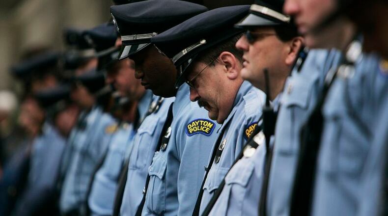 Dayton Police officers lower their heads during a Montgomery County Law Enforcement Memorial ceremony. Jim Noelker/Dayton Daily News