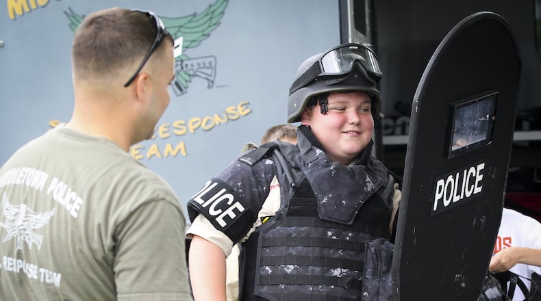 Tobi Wilder, 12, of Middletown, tries on Special Response Team tactical gear with the help of Gary Bender during the 2014 Middletown Division of Police annual National Night Out. GREG LYNCH / STAFF