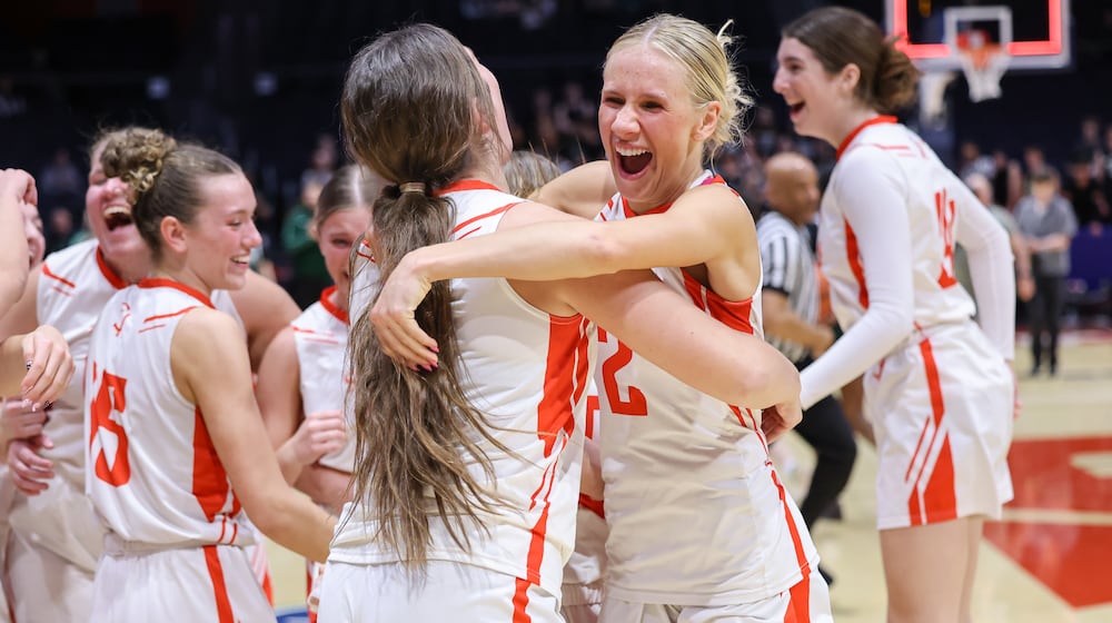 St. Henry senior guard Alexis Buschur hugs senior forward Molly Wendel shortly after the buzzer sounds in the Division VI state championship on Friday, March 13 at University of Dayton Arena. The Redskins beat Canton Central Catholic 53-34 to win the program's first state title. BRYANT BILLING / STAFF
