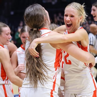 St. Henry senior guard Alexis Buschur hugs senior forward Molly Wendel shortly after the buzzer sounds in the Division VI state championship on Friday, March 13 at University of Dayton Arena. The Redskins beat Canton Central Catholic 53-34 to win the program's first state title. BRYANT BILLING / STAFF