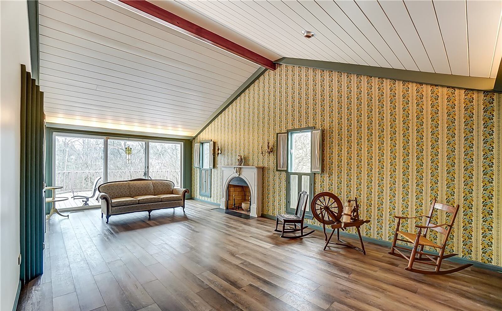 The main level living room has laminate flooring, a vaulted ceiling and decorative fireplace. This room also opens to the wrap around wood deck.