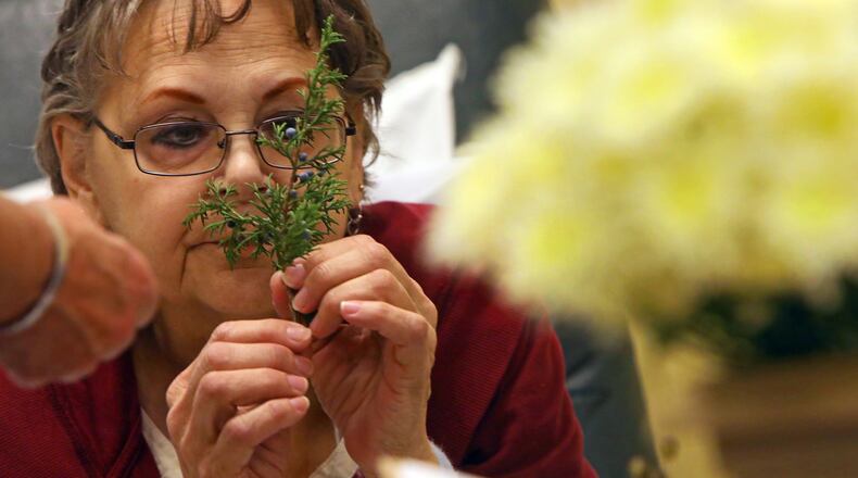 Fran Niemeyer-Murphy, of Fenton, smells an aromatic clipping to build a therapeutic bouquet as she gets treatment on Thursday, Nov. 30, 2017, at Siteman Cancer Center. Jeanne Carbone, a therapeutic horticulture instructor, offers therapeutic horticulture outreach at local medical and trauma centers through a program at the Missouri Botanical Garden. (Christian Gooden/St. Louis Post-Dispatch/TNS)