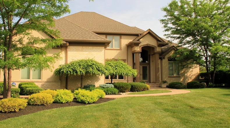 The home sits at the end of a cul-de-sac with a 3-car, side-entry garage, a balcony wooden deck, a covered concrete patio and a tree-lined back yard that overlooks a pond with a fountain. CONTRIBUTED PHOTOS BY KATHY TYLER