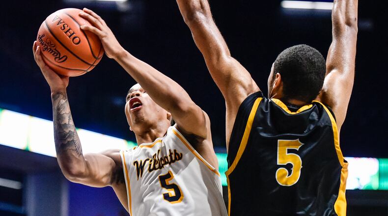Springfield’s RaHeim Moss goes to the hoop defended by Centerville’s Mo Njie during their Division I regional boys basketball semifinal Wednesday, March 13 at Xavier University’s Cintas Center in Cincinnati. Centerville won 67-63. NICK GRAHAM/STAFF