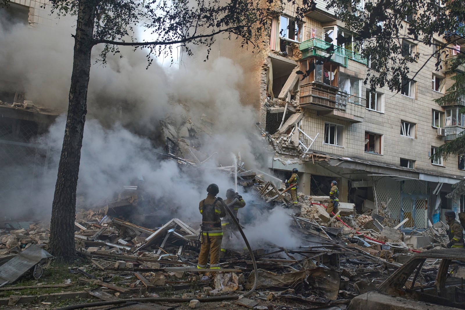 Firefighters put out the fire after a Russian missile hit a residential building during Russia's massive missile and drone air attack in Kyiv, Ukraine, Tuesday, June 17, 2025. (AP Photo/Efrem Lukatsky)