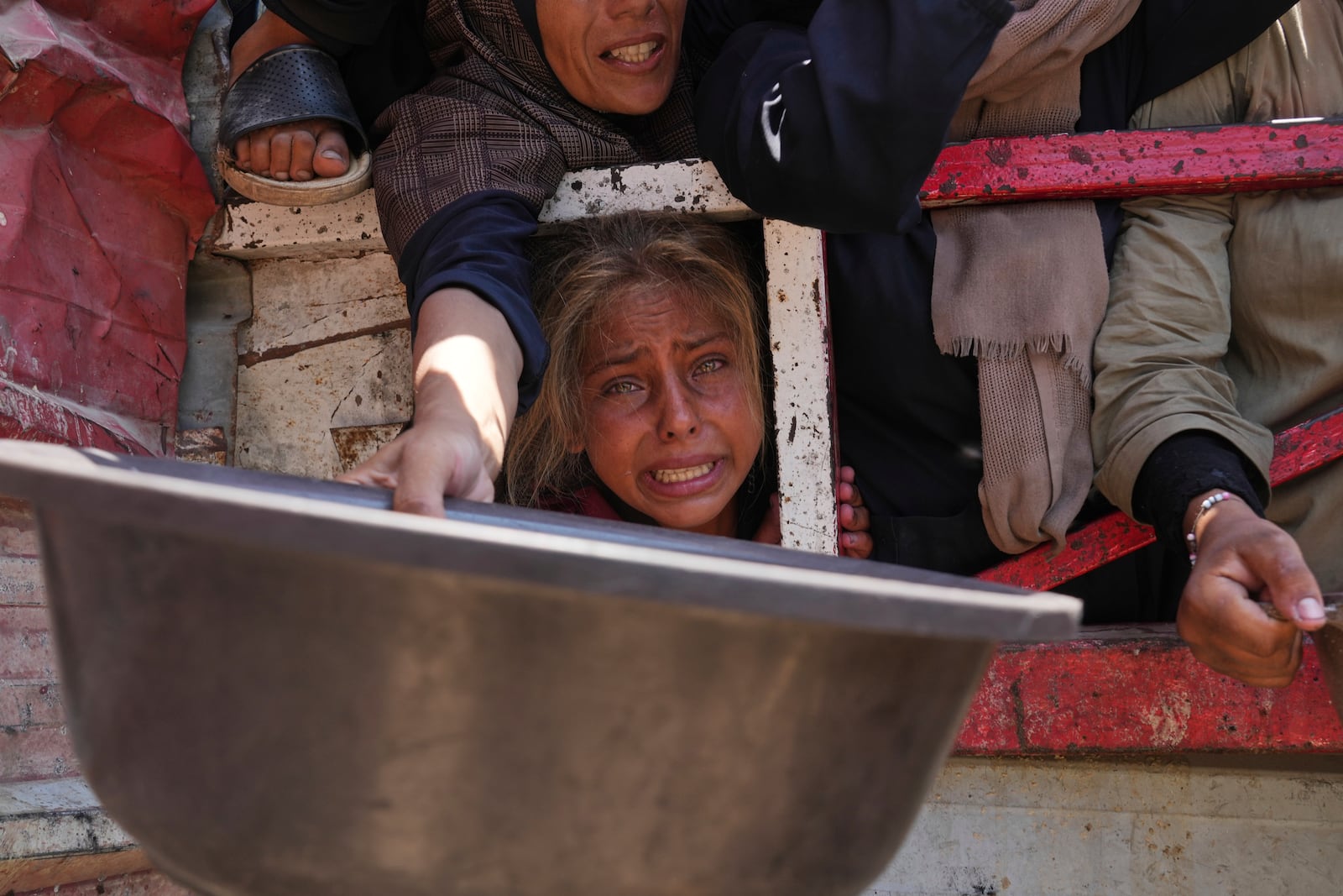 Palestinians struggle to get donated food at a community kitchen, in Gaza City, northern Gaza Strip, Saturday, July 26, 2025. (AP Photo/Abdel Kareem Hana)
