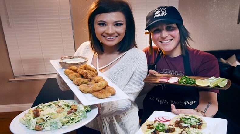Ashley Hankins-Marchetti, left, and Ashlee Marchetti, right, create plant-based food for their blog titled Eat Figs Not Pigs. Shown left to right is Caesar salad with cashew-based dressing, pano battered fried artichokes, and street-style tacos with textured soy proten for filling. (Eric Paul Zamora/Fresno Bee/TNS)