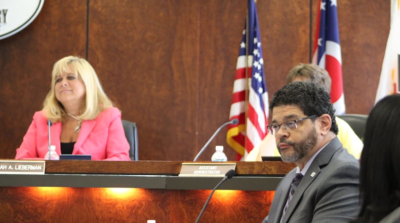 Montgomery County Commissioner Debbie Lieberman and assistant county administrator Tom Kelley listen to YWCA Dayton leaders criticize the decision to no longer fund a domestic violence hotline. CORNELIUS FROLIK / STAFF