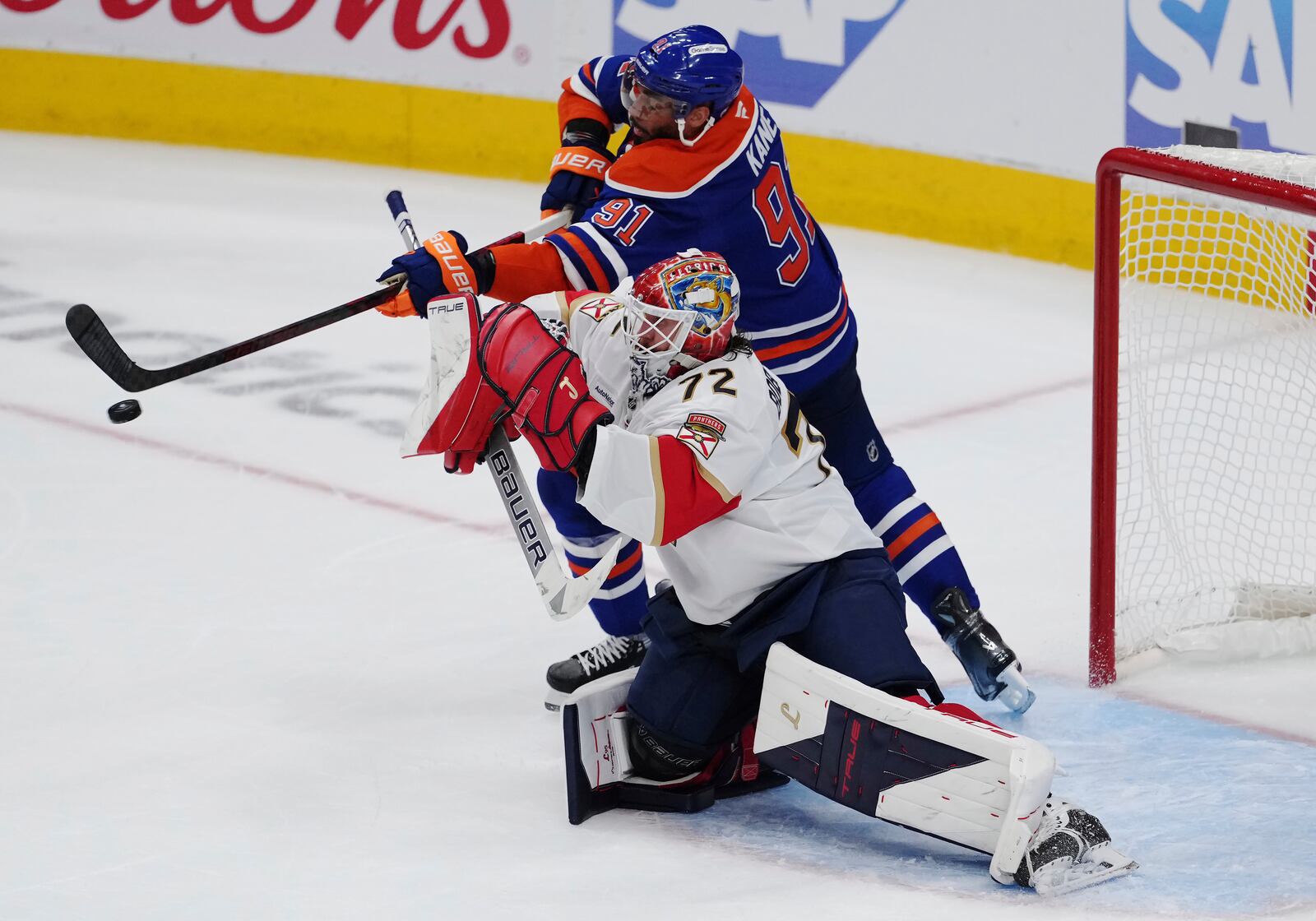 Edmonton Oilers' Evander Kane (91) tries to tip the puck past Florida Panthers goalie Sergei Bobrovsky (72) during the third period in Game 1 of the NHL Stanley Cup Final, in Edmonton, on Wednesday, June 4, 2025. (Darryl Dyck/The Canadian Press via AP)