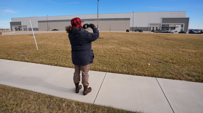 A man takes photos of a warehouse as federal officials tour the facility to consider repurposing it as an ICE detention facility Thursday, Jan. 15, 2026, in Belton, Mo. (AP Photo/Charlie Riedel)