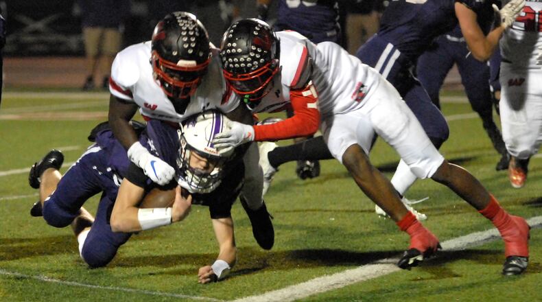 Lakota West's Cole Munday and Taebron Bennie-Powell (right) tackle an Elder ball carrier during a Division I regional semifinal game on Friday, Nov. 11, 2022. Bennie-Powell signed with Notre Dame on Wednesday, the first day of the national signing period. DAVID A. MOODIE/CONTRIBUTING PHOTOGRAPHER
